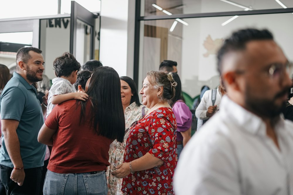 Personas que se saludan y se abrazan a la entrada de una iglesia.